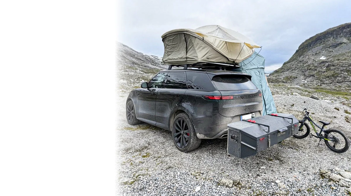 IXTAbox cargo box mounted behind a car with a rooftop tent in the mountains